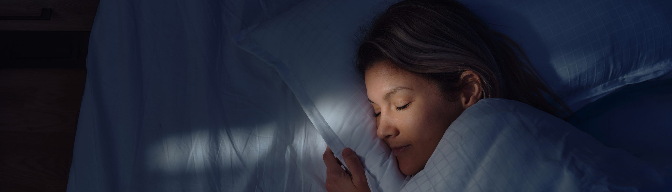 Above view of relaxed woman sleeping in bed at night.