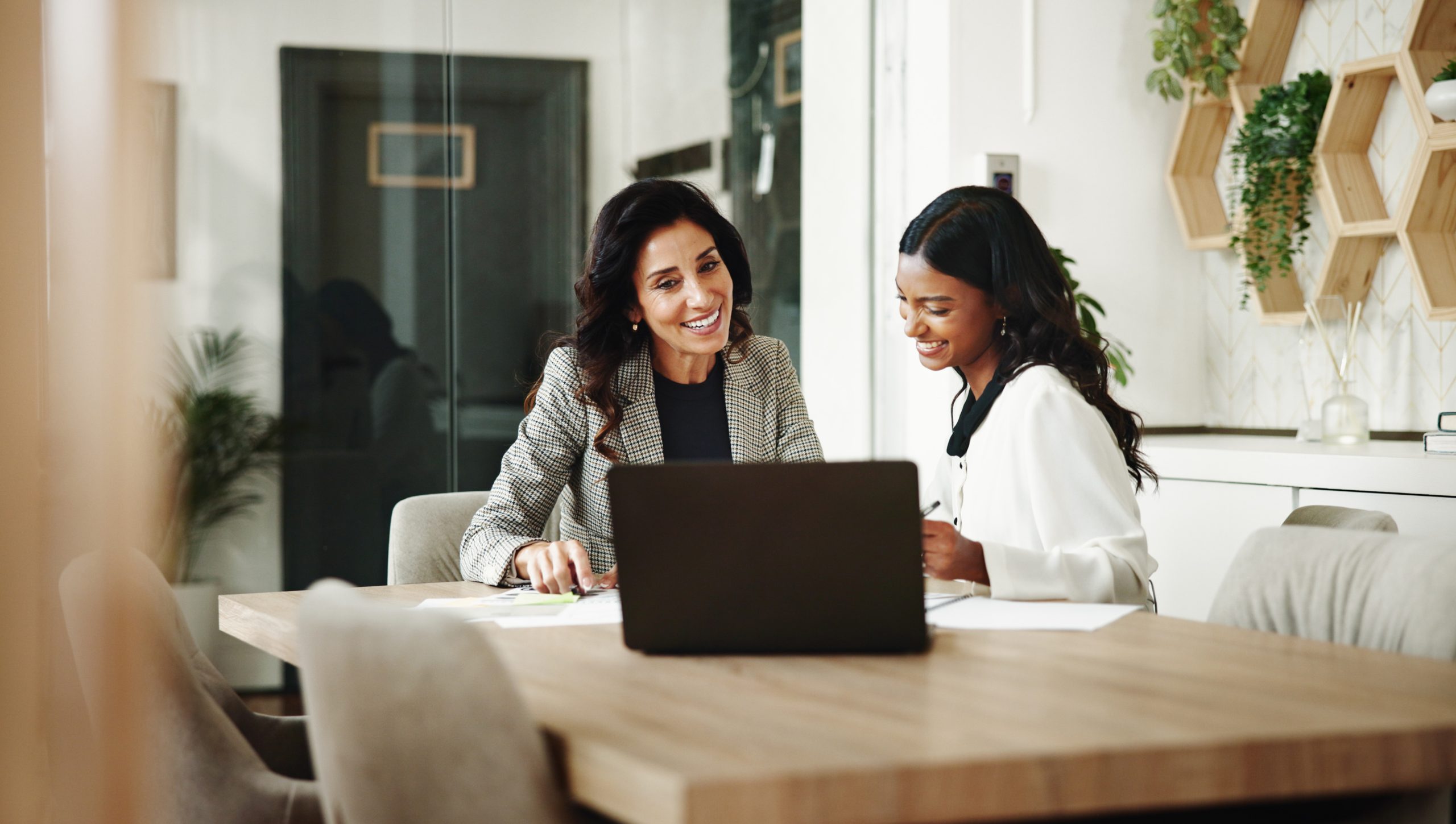Hotel professionals reviewing mattress vendor options together on a laptop